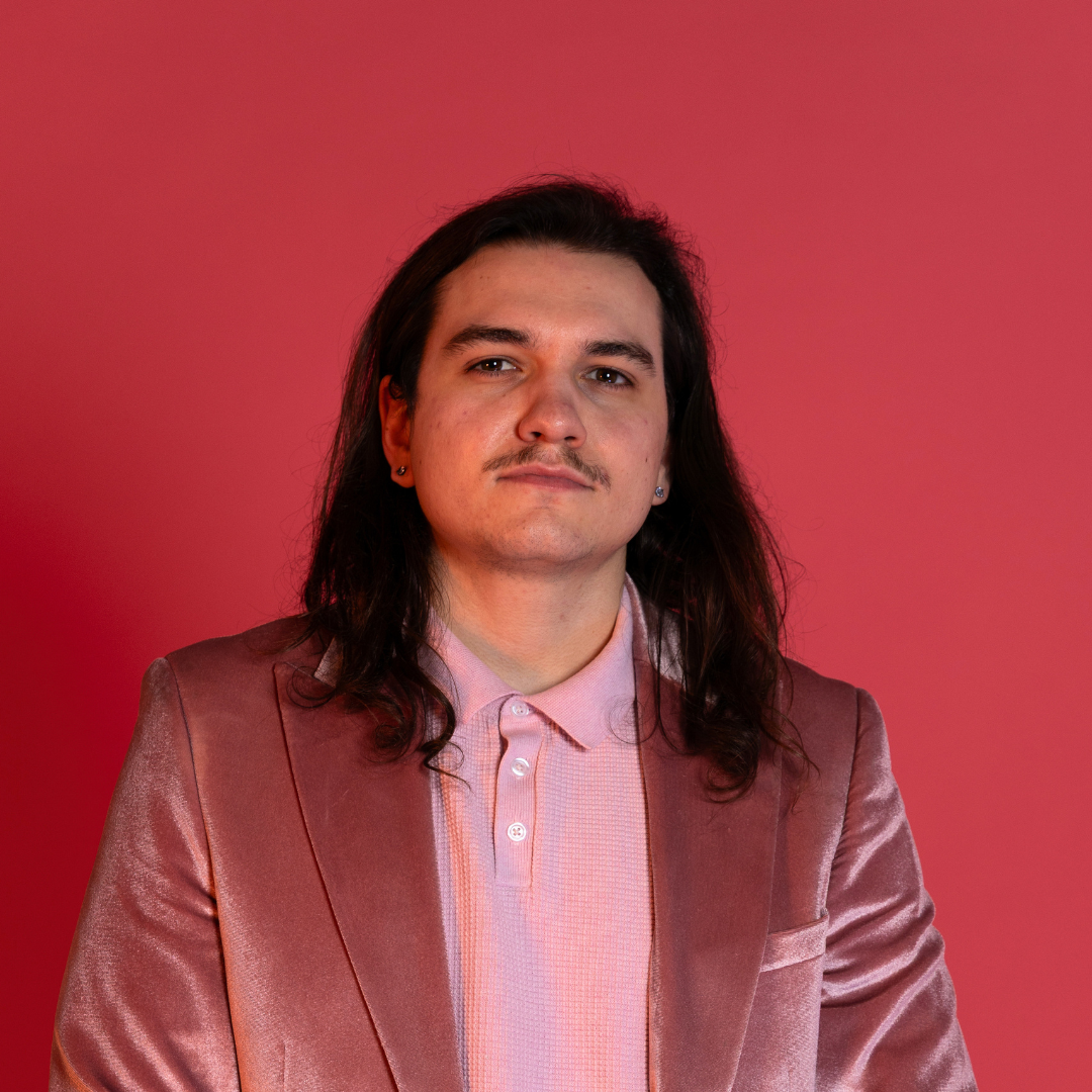 Nathan Wheeler Headshot. Pink velvet jacket