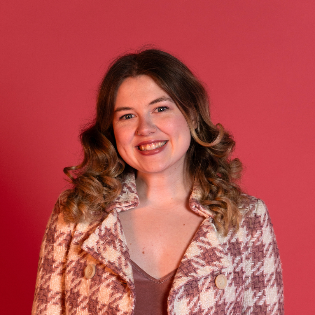 Esme Michale Headshot. Pink houndstooth blazer